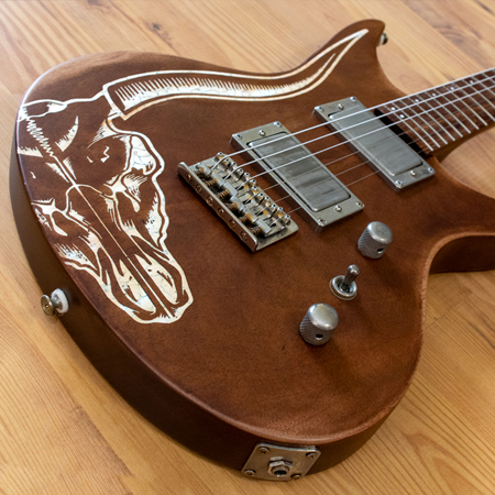 Naturally finished Mahogany six string electric guitar with a white inlaid cow skull