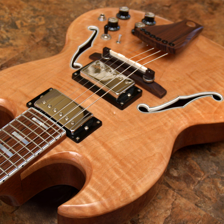 SG style hollow bodt six string electric guitar with a Flamed Maple top and white bound F holes